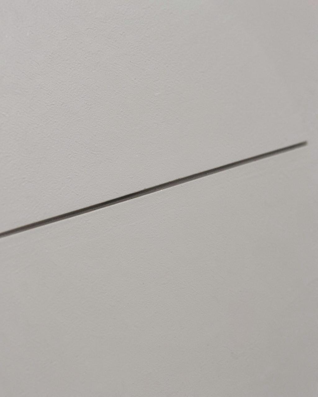 Concealed door seam flush with a painted wall