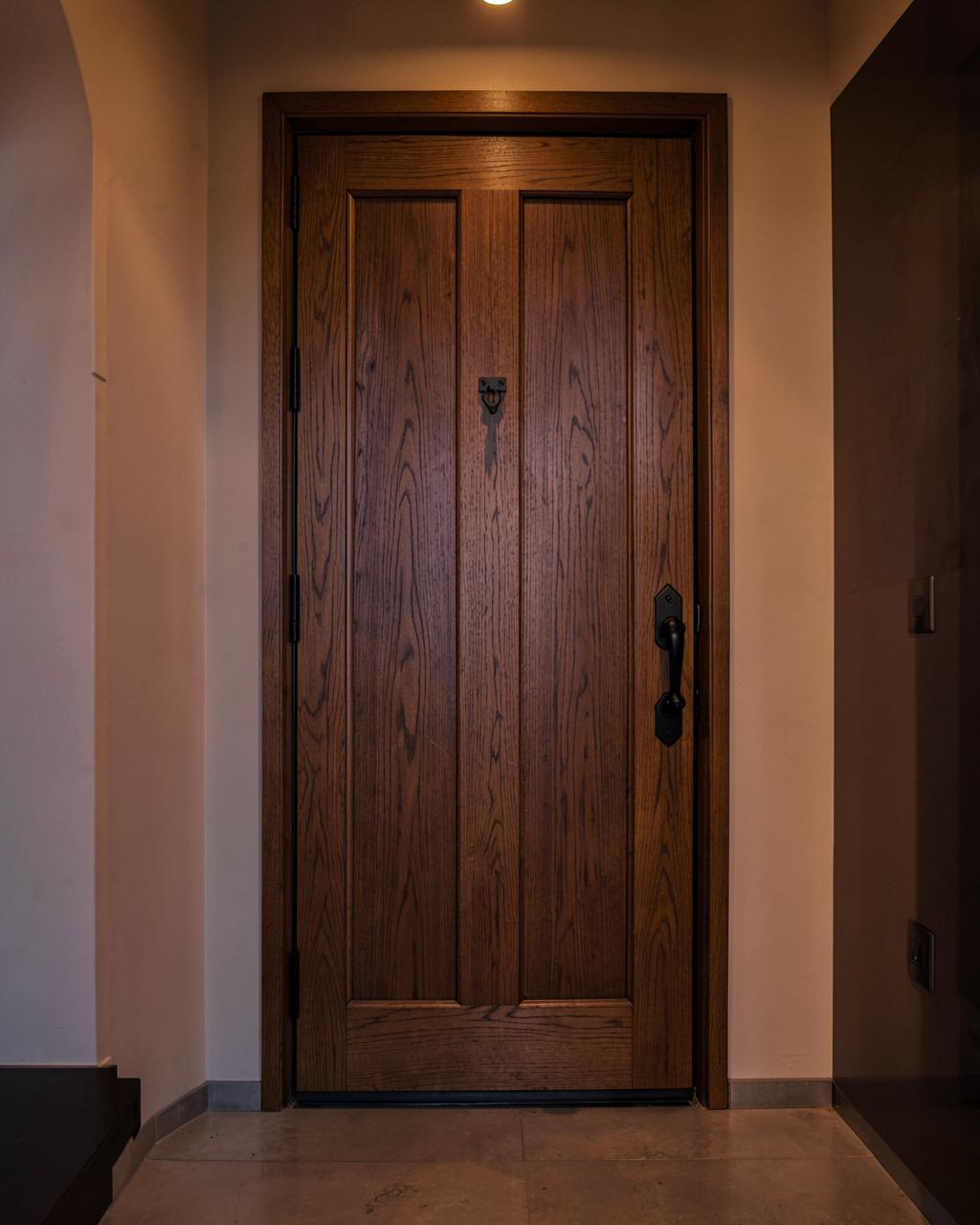 Timber pivot front door with black hardware in a modern entryway
